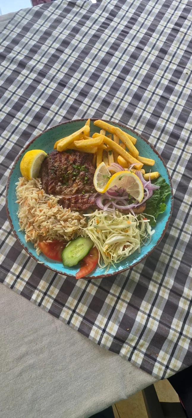 Pork steak with rice, fries and cabbage salad
